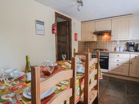 A dining room with a table set for a meal at Cider Cottage in Hawkchurch