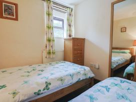 A bedroom with two single beds and a wooden drawer at Cider Cottage in Hawkchurch