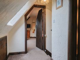 A hallway with a door and a TV in view at Cider Cottage in Hawkchurch