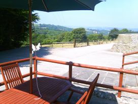 An outdoor area with a table and umbrella at Cider Cottage in Hawkchurch