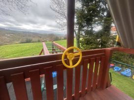 A playground structure with a steering wheel and slide at Cider Cottage in Hawkchurch