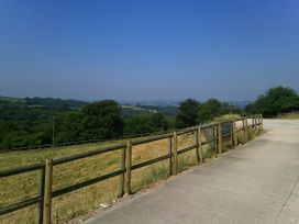 An outdoor landscape with a fence and road at Cider Cottage in Hawkchurch