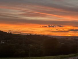 A sunset view over fields and hills at Cider Cottage in Hawkchurch