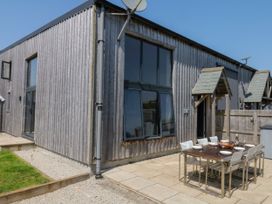 An outdoor dining area with a table and chairs at Fieldstone Barn North Tawton