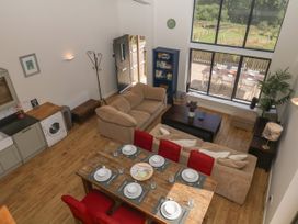 A living room with a sofa and dining area at Fieldstone Barn North Tawton