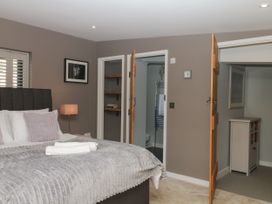 A bedroom with a bed and shelves at Fieldstone Barn in North Tawton