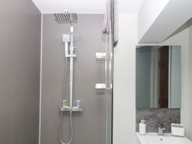 A bathroom with a shower and mirror at Fieldstone Barn North Tawton