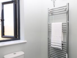 A bathroom with a heated towel rail and window at Fieldstone Barn in North Tawton