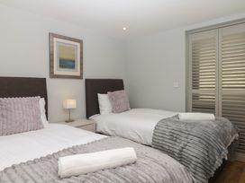 A bedroom with two beds and a lamp on a nightstand at Fieldstone Barn in North Tawton