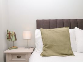 A bedroom with a bed and lamp at Fieldstone Barn North Tawton