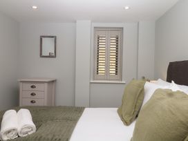 A bedroom with a bed and dresser at Fieldstone Barn North Tawton