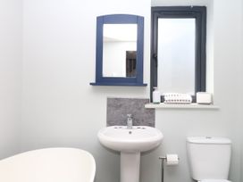 A bathroom with a bathtub, sink, and toilet at Fieldstone Barn in North Tawton