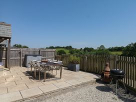 An outdoor patio with a table and chairs at Fieldstone Barn in North Tawton