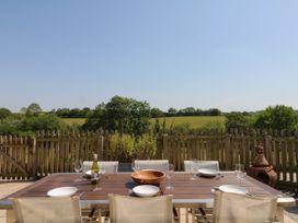 An outdoor dining area with a table and chairs at Fieldstone Barn in North Tawton