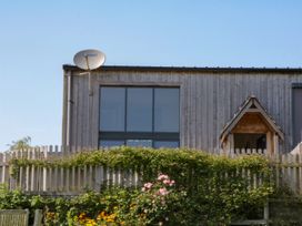 An exterior view of a wooden house with a satellite dish at Fieldstone Barn North Tawton