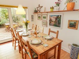 A dining room with a wooden table set for a meal at 1 Rosemount Garden Villas in Tenby