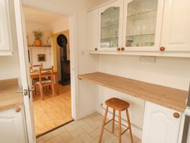 A kitchen with a table and chairs visible in another room at 1 Rosemount Garden Villas Tenby