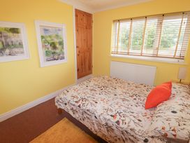 A bedroom with a bed and paintings on the wall at 1 Rosemount Garden Villas Tenby