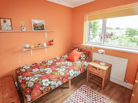 A bedroom with a bed and shelves at 1 Rosemount Garden Villas, Tenby