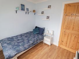 A bedroom with a bed and shelf at 1 Rosemount Garden Villas Tenby