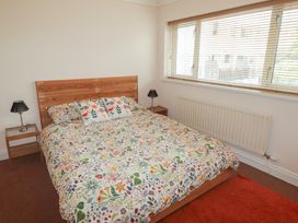 A bedroom with a bed and bedside tables at 1 Rosemount Garden Villas Tenby