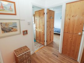 A hallway with wooden doors and a storage basket at 1 Rosemount Garden Villas in Tenby