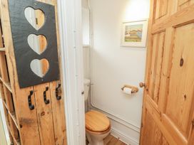 A bathroom featuring a toilet and wooden elements at 1 Rosemount Garden Villas Tenby