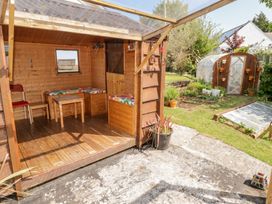 A garden with a wooden shed and plants at 1 Rosemount Garden Villas in Tenby
