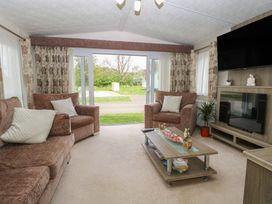 A living room with a sofa and coffee table at The Norfolk Nook 18 Castle Walk Burgh Castle