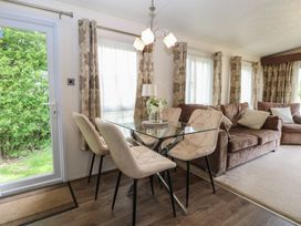A dining room with a table and chairs at The Norfolk Nook 18 Castle Walk Burgh Castle