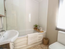 A bathroom with a bathtub and sink at The Norfolk Nook 18 Castle Walk Burgh Castle