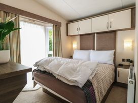 A bedroom with a bed and plant at The Norfolk Nook 18 Castle Walk Burgh Castle