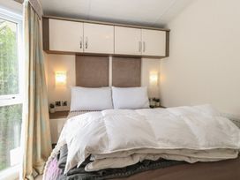 A bedroom with a bed and wardrobe at The Norfolk Nook 18 Castle Walk Burgh Castle