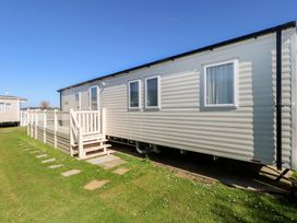A mobile home with a deck and steps at Seaside Retreat in Selsey