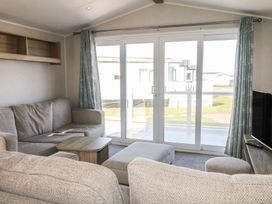 A living room with sofa and sliding door at Seaside Retreat in Selsey