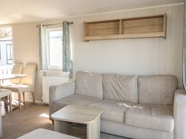 A living room with a sofa and table at Seaside Retreat in Selsey