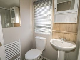 A bathroom with a toilet and sink at Seaside Retreat Selsey