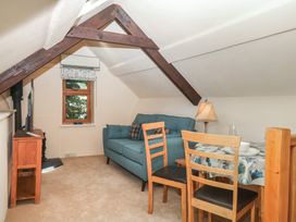 A living room with a sofa, table, and chairs at The Mill Barn in Lustleigh