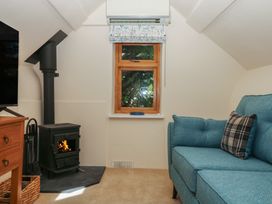 A sitting room with a sofa and stove at The Mill Barn in Lustleigh