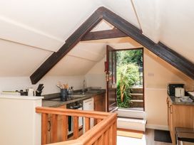 A kitchen with countertop and an open door leading outside at The Mill Barn in Lustleigh