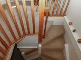 A staircase with wooden handrail and carpet at The Mill Barn in Lustleigh