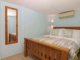 A bedroom with a bed and a mirror at The Mill Barn in Lustleigh