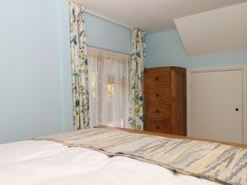A bedroom with a bed and dresser at The Mill Barn in Lustleigh