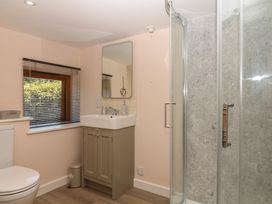 A bathroom with a sink, toilet, and shower at The Mill Barn in Lustleigh