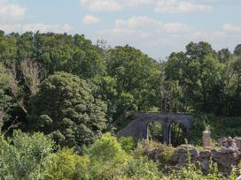 A bridge surrounded by trees and foliage at The Mill Barn in Lustleigh