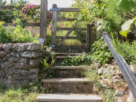 A gate and stone steps leading up to a garden at The Mill Barn in Lustleigh