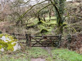 A gate with a path and rocks in a natural setting at The Mill Barn in Lustleigh