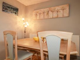 A dining room with a table, chairs, and a lamp at Moorland View Belowda near Roche