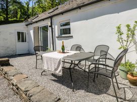 An outdoor dining area with a table and chairs at Daffodil Cottage in Blaencwm near Treorchy