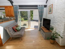 A living room with a sofa and television at Daffodil Cottage in Blaencwm near Treorchy